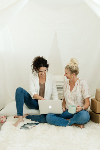 The pearl project founder jen looking at a laptop with friend