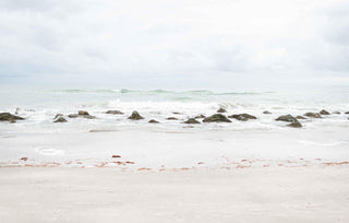 Photo of waves crashing on rocks on the beach