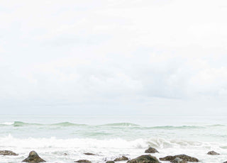 Photo of waves crashing on rocks on the beach