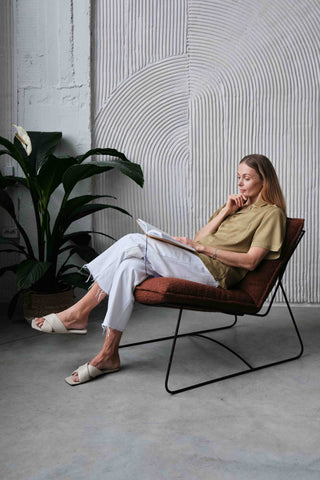 Woman sitting in chair reading a journal